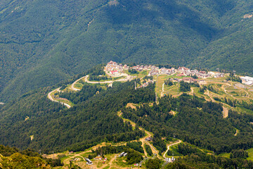 Top view of resort town with hotels on background of mountains. Beautiful landscape of hotels located in mountains in summer