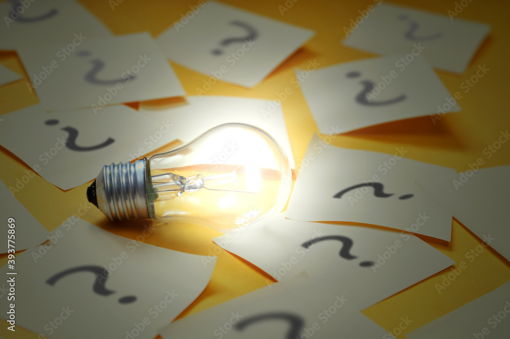 Poster a burning lamp surrounded by stickers with a question mark. the emergence of the idea of solving a d