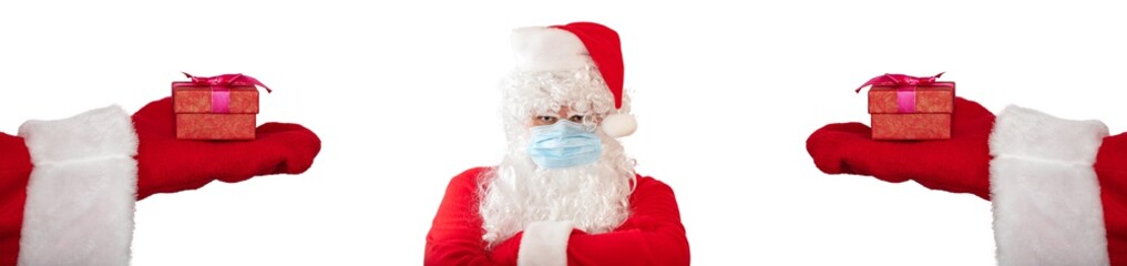 Santa Claus wearing a medical mask and has his arms crossed on his chest, looks very angry. Two hands with gifts extended to him on both sides. Isolated on white background. Banner size, copy space