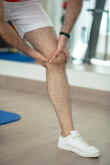 Naklejka premium Close-up of male hands massaging painful knee