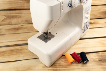 Electric sewing machine with sewing accessories isolated on white background