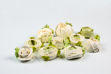 Close up of delicate marshmallows on a white background of a delicate light green color