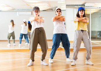 Fototapeta premium Focused teenage hip hop dancers doing dance workout during group class
