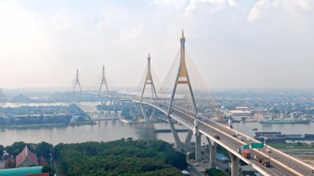 Time lapse of modern district cityscape and Bhumibol Bridge with cloud pass over buildings and skyscrapers with transportation in city. Bangkok, Thailand