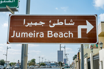 Fototapeta premium Road sign of Jumeira Beach in English and Arabian language, a famous resort in Dubai, United Arab Emirates