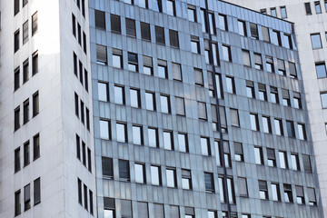 Abstract view of a skyscraper. Exterior of a glass office building with symmetrical lines and light gray colors.