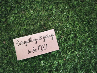 Motivational and inspirational quote - everything is going to be ok text written on paper background. Stock photo.