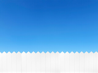 White wooden fence and on a clear blue sky background