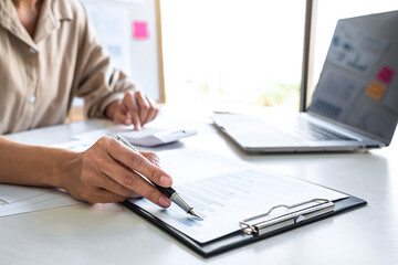 Professional at work, business woman working and analyzing on laptop with calculate statistics of financial document data graph for new project of business strategy and market growth at workplace