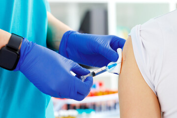 Doctor hands making a vaccination in the shoulder of patient