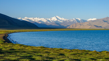 View from the shores of Karakul lake at sunrise, with Muskol snow-capped mountain range in the background, Murghab district, Gorno-Badakshan, in the Pamir region of Tajikistan