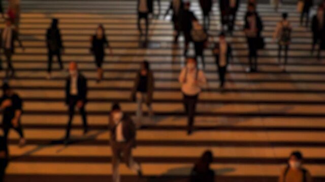 TOKYO, JAPAN : Aerial high angle view of crowd of people walking at zebra crossing in rush hour. Commuters at the street. Japanese city life style, business and work concept. Slow motion blurred shot.