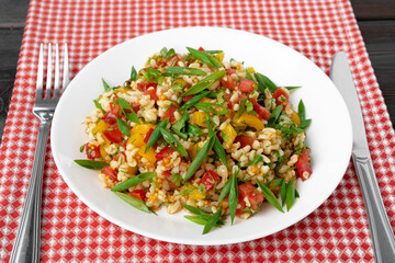 Georgian Tabbouleh salad with bulgur and vegetables on black wooden table