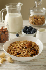 Concept of tasty breakfast with granola on wooden background