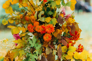 Part of a colorful wedding arch of autumn leaves and flowers on the background of the autumn...