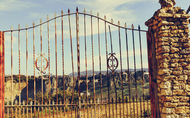 Old gate and Ronda town in distance, Spain.
