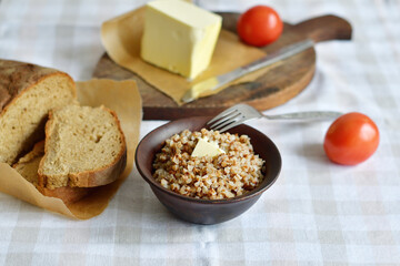 Buckwheat porridge with butter.Bowl of tasty buckwheat porridge on wooden table.Healthy breakfast for schoolchildren.