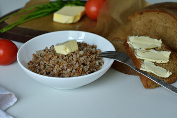Buckwheat porridge with butter.Bowl of tasty buckwheat porridge on wooden table.Healthy breakfast for schoolchildren.