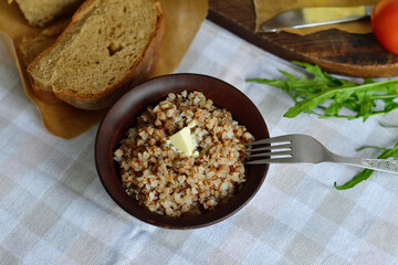 Bowl of tasty buckwheat porridge on wooden table.Healthy breakfast for schoolchildren.
