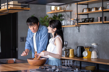 Fototapeta premium キッチンで料理する夫婦 