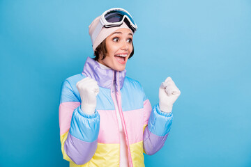 Photo of pretty lucky girl raise fists look copyspace wear white gloves hat winter vacation isolated on blue color background