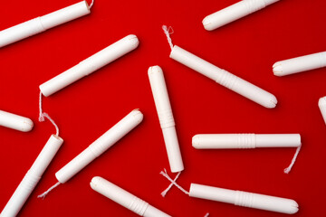 Pile of female tampons on red background