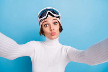 Photo of pretty skier girl make selfie send air kiss wear white turtleneck stylish isolated on blue color background