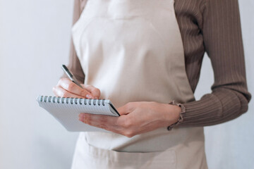 Waitress in apron makes a note