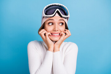 Photo of worried scared young woman look empty space bite nails afraid ski isolated on blue color...