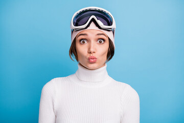 Photo of funky charming young woman send air kiss funny mood winter vacation isolated on blue color background