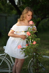 Beautiful girl with white bike in the park