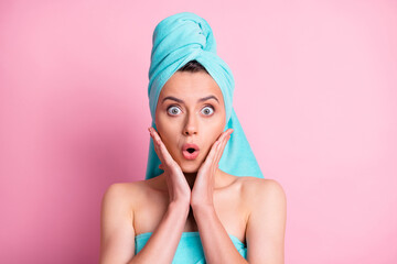 Portrait of young attractive shocked amazed surprised girl wear teal turban towel hold hands cheeks isolated on pink color background