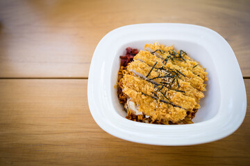 Korean hot and spicy instant noodles with fried chicken on the wooden table.