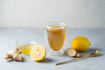 Healthy living herbal tea; lemon honey tea with ginger root on a gray background