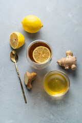 Healthy living herbal tea; lemon honey tea with ginger root on a gray background