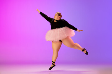 Prima. Beautiful caucasian plus size model practicing ballet dance on gradient purple-pink studio background in neon light. Concept of motivation, inclusion, dreams and achievements.