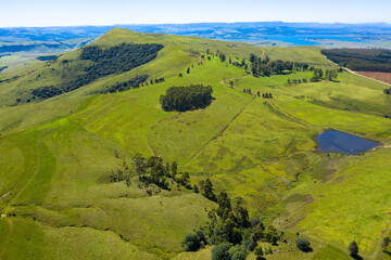 Fototapeta na wymiar Panoramic aerial view of green meadows on mountain slope on a clear day, Panorama Route South Africa