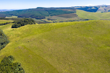 Panoramic aerial view of green meadows on mountain slope on a clear day, Panorama Route South Africa