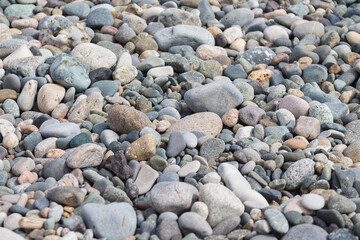Fototapeta na wymiar The texture of sea pebbles on the shore. Pebbles close-up.