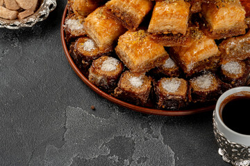 Assortment of turkish baklava on black textured surface