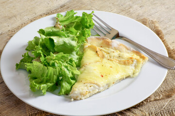part de tarte aux maroilles et salade dans une assiette