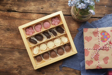 Candy of different shapes and heart on a wooden table, flat lay with space for text. Valentine's...