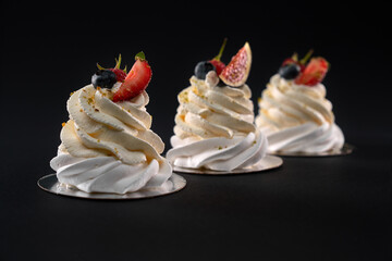 Whipped cream dessrt decorated with berries isolated on black.