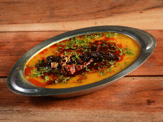 Authentic Indian popular food Dal Tadka Curry or Traditional Indian soup lentils on rustic wooden background. selective focus