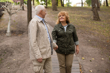Happy senior couple in love on a walk in autumn nature, senior couple relax in spring time.