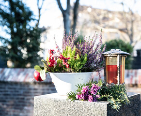 Herbstblumen und ein Grablicht zum Totensonntag
