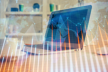 Financial chart drawing and table with computer on background. Double exposure. Concept of...