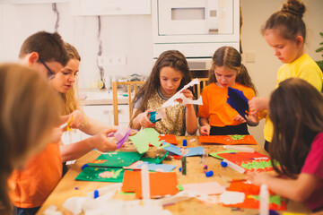 Teacher and her pupils making paper handicrafts - 393814840