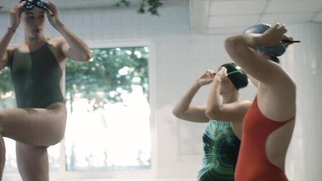 Happy students of swimming preparing before start swims and training swimming techniques. Slow motion shot. 