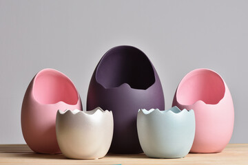 Set of multicolored vases in the form of an eggshell on a gray background for easter